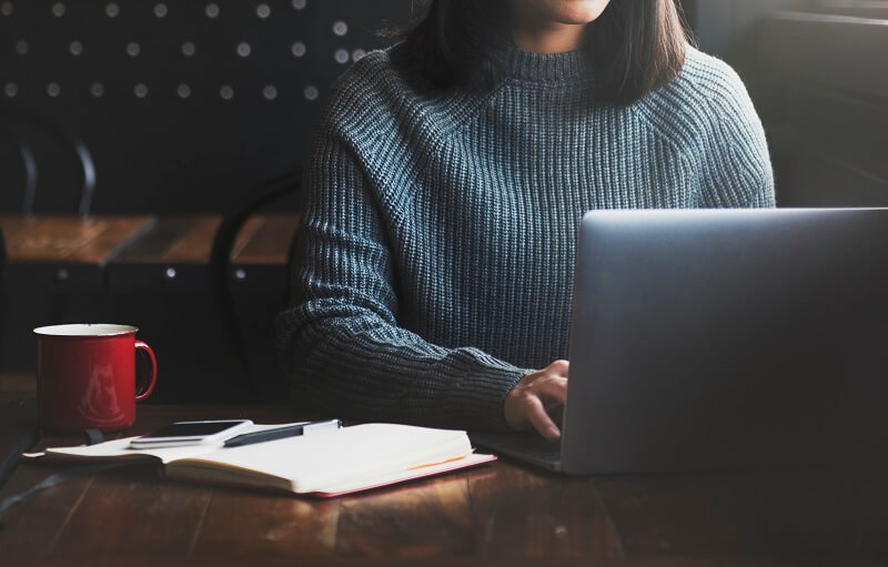 woman at a laptop applying for an online teaching degree