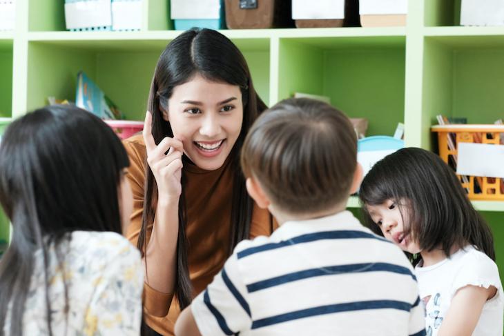 English teacher with students in an ESL classroom.