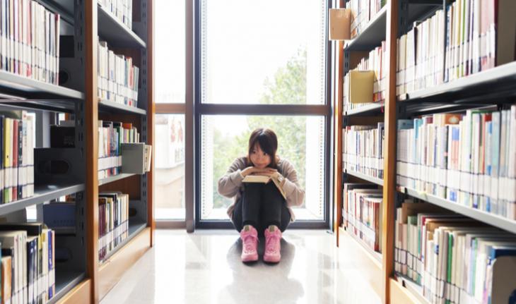 student sitting in a library for new article on china's private tutoring regulations