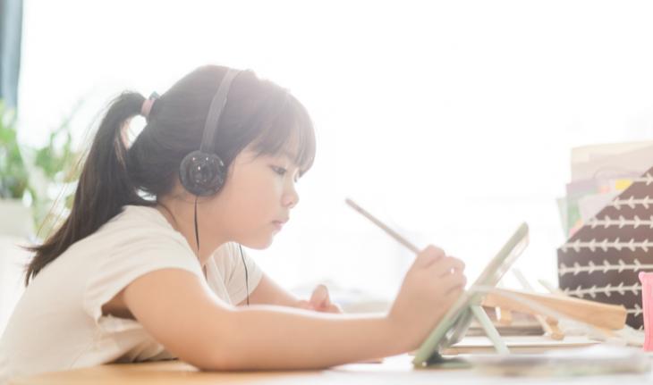 young student learning on a tablet for china new tutoring policy article